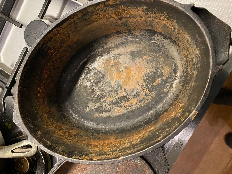 A worn cast iron pan with patchy seasoning